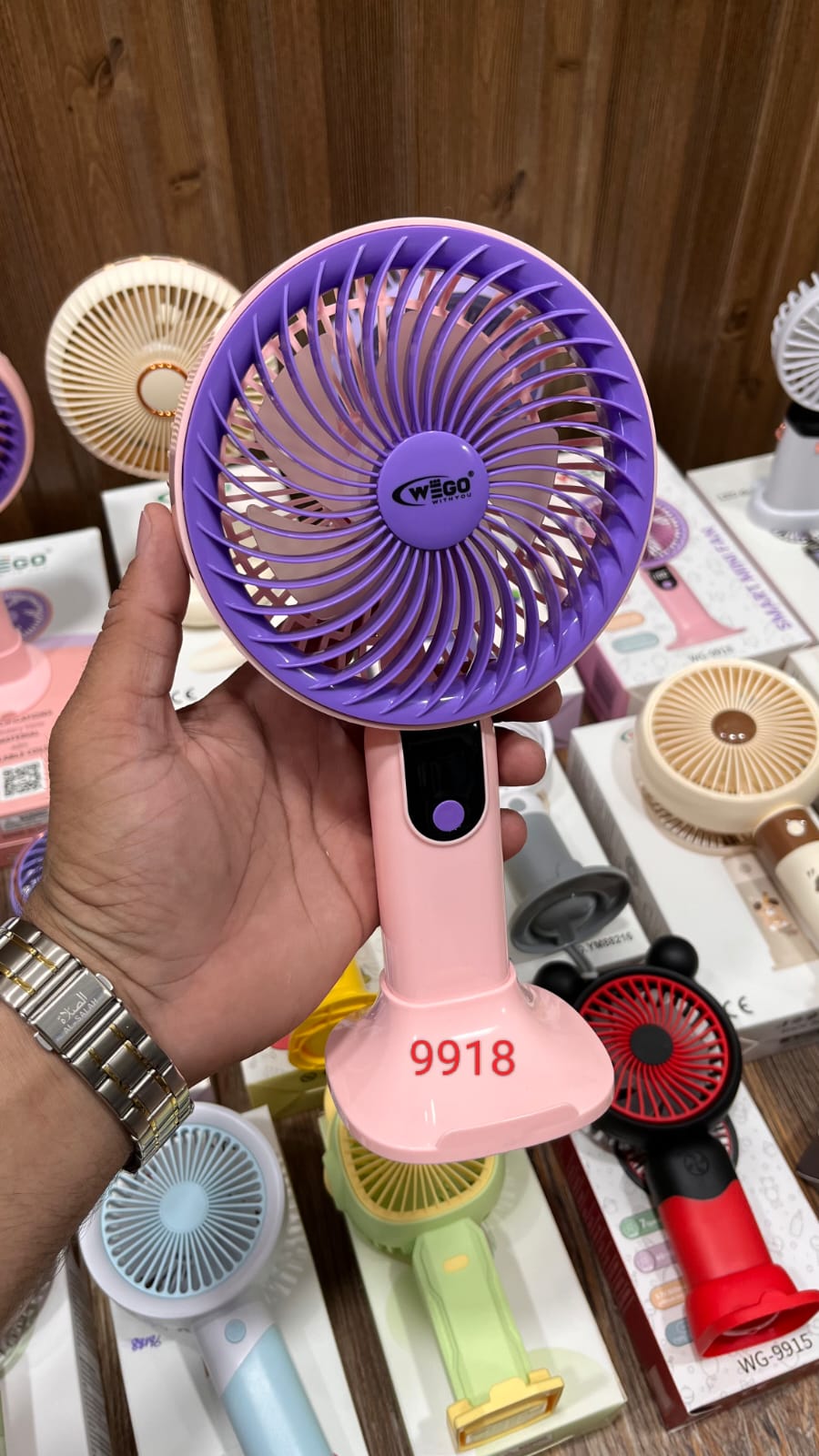 Wego portable rechargeable mini cooling fan featuring a digital display, five-speed settings, and a pink handle with a purple cage