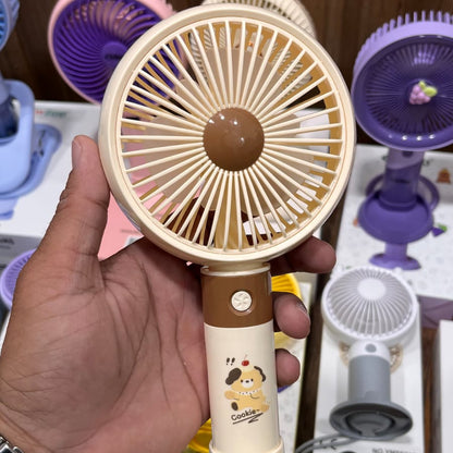 Portable Rechargeable Fan in a beige color with a cartoon design on the handle