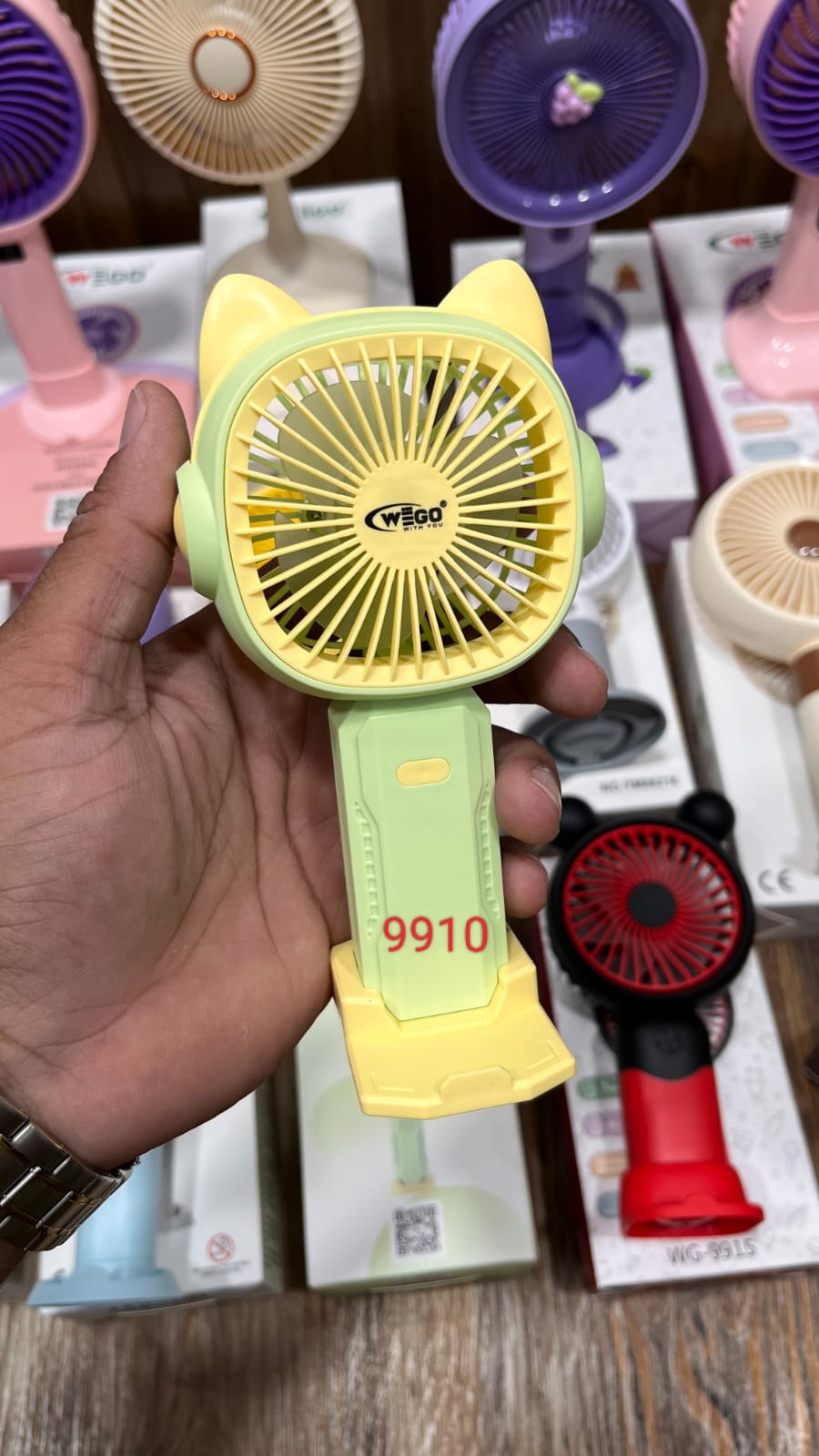 WEGO rechargeable cartoon handheld fan with a yellow cat-eared fan head and a light green handle..