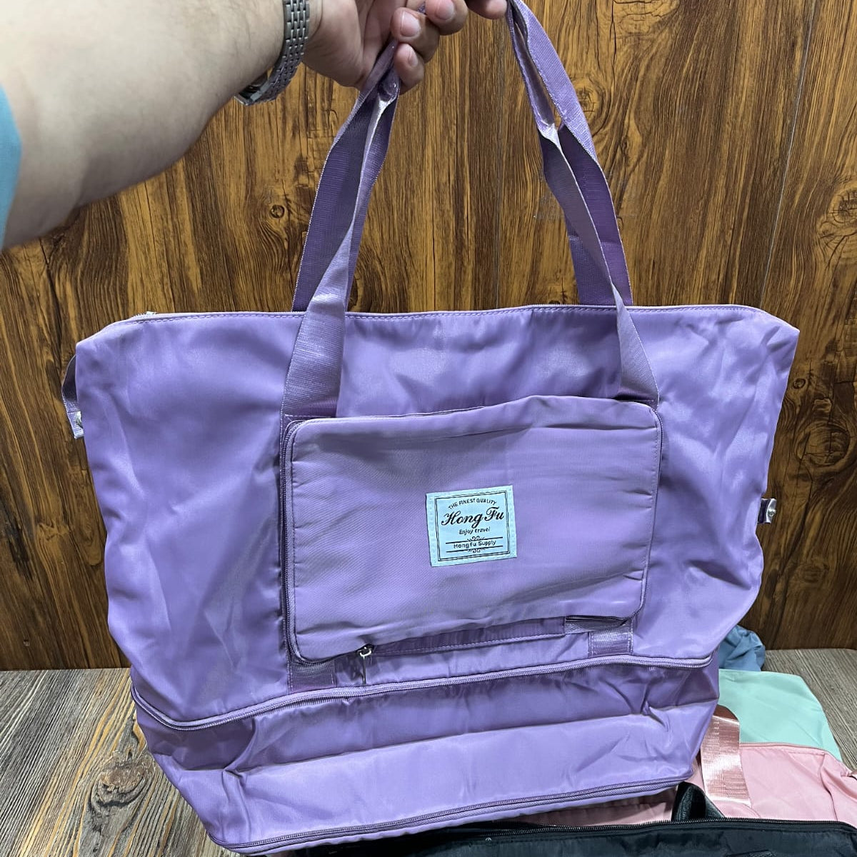 Hong Fu branded lilac purple foldable travel bag made from lightweight waterproof fabric.